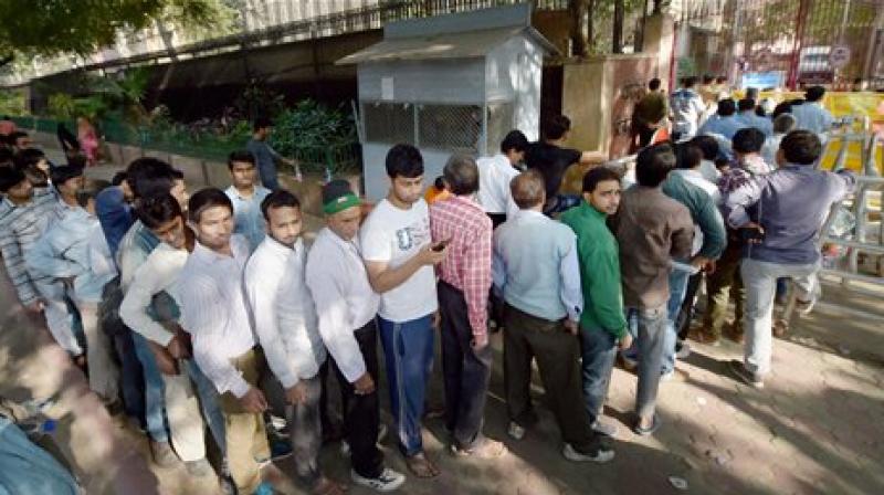People stand in a long queue to deposit and exchange their old currency notes. (Photo: PTI)