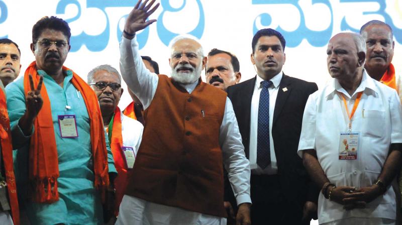 Prime Minister Narendra Modi and BJP leaders B.S. Yeddyurappa and R. Ashok at a campaign programme in Hubballi on Sunday.