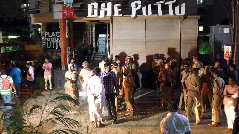 Police personnel and local residents near Dhe Puttu restaurant owned by actor Dileep in Kochi on Monday night. (Photo: ARUNCHANDRA BOSE)
