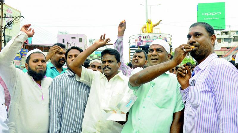 TD leaders led by NUDA Chairman K. Srinivasulu Reddy and mayor S.K. Abdul Aziz celebrate TDs victory in Nandyal by distributing sweets after offering floral tributes to NTRs statue in Nellore. (Photo: DC)