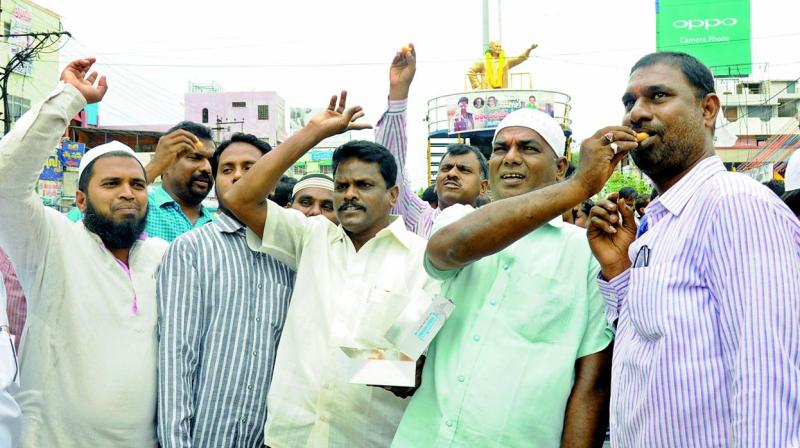 TD leaders led by NUDA Chairman K. Srinivasulu Reddy and mayor S.K. Abdul Aziz celebrate TDs victory in Nandyal by distributing sweets after offering floral tributes to NTRs statue in Nellore. (Photo: DC)