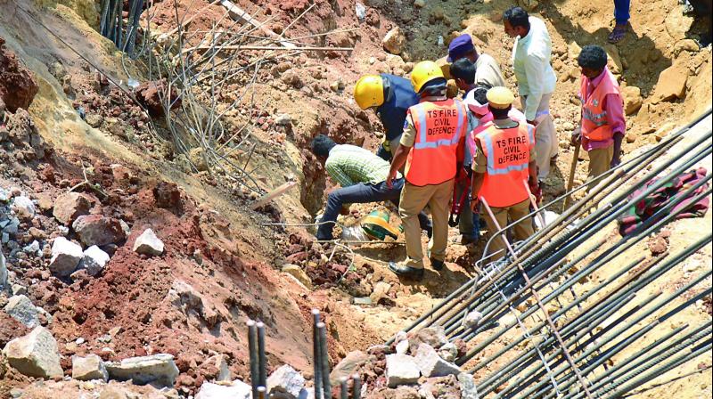 Workers try to remove mud that fell on workers at the Kondapur site on Tuesday.