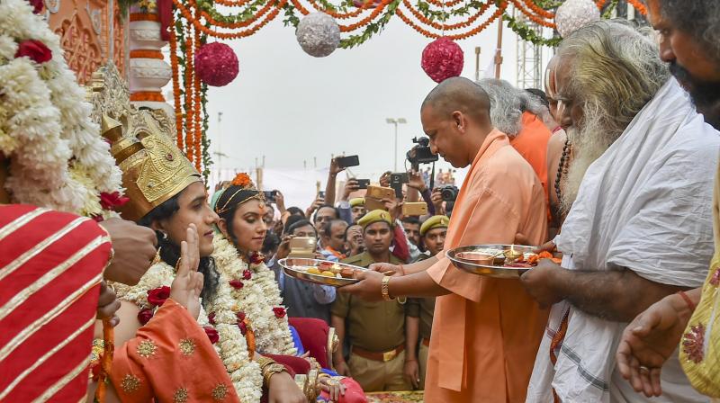 Uttar Pradesh Chief Minister Yogi Adityanath performs arti of the aristises dressed as Lord Ram, Sita and Laxman after their arrival for the Deepotsav on Tuesday. (Photo: PTI)