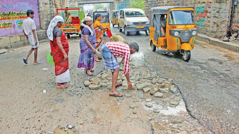 Corporation workers carry out a patch work on roads damaged during rains at Vyasarpadi on Monday. (Photo: DC)
