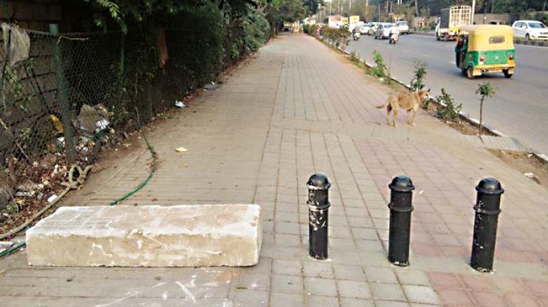 A cement block placed by the traffic police on the footpath near Byappanahalli Metro Station to stop two-wheeler  riders from riding on footpaths	(Photo: DC)