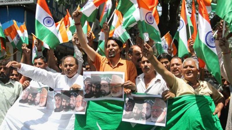 Shiv Sena activists burn the Pakistan flag and raise slogans against Hurriyat leaders over ceasefire violation and killing of army officer in Kashmir recently, at Jammu on Thursday. (Photo: PTI)