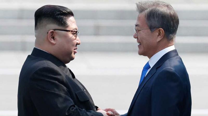 Men in sharp suits and matching blue and white striped ties fanned out ahead of and around Kim (L) as he approached the Military Demarcation Line for a historic handshake with his Southern counterpart Moon Jae-in. (Photo: AFP)
