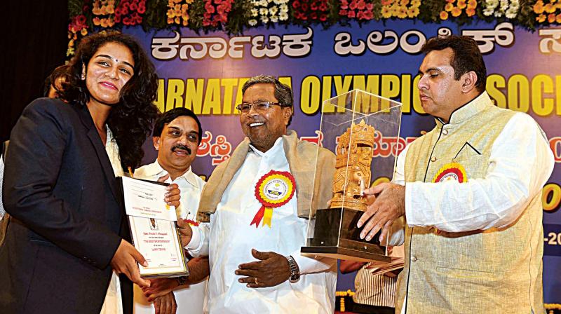 CM Siddaramaiah presents Karnataka Olympic Association awards in Bengaluru on Monday. Minister for Sports and Youth Affairs Pramod Madhwaraj is seen. (Photo: KPN)
