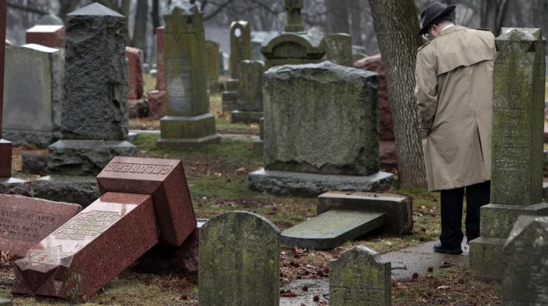 People walk through toppled graves at Chesed Shel Emeth Cemetery in University City, Mo., on Tuesday. (Photo: AP)