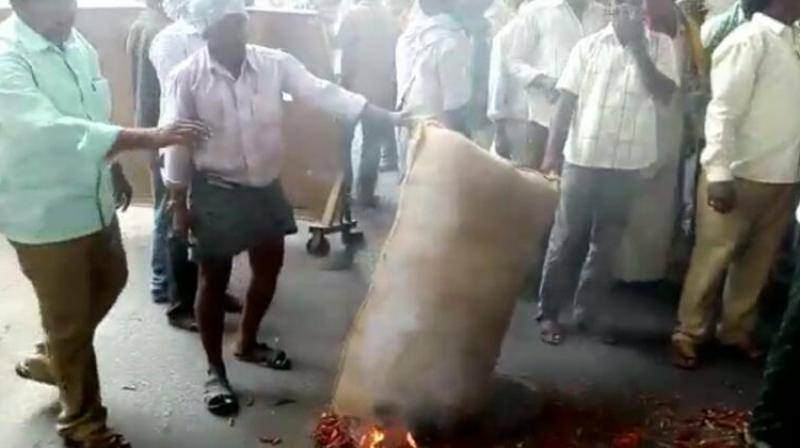 Farmers set fire to a bag of chilli at the Mahbub Mansion Market in Hyderabad, after they were offered rock bottom prices.