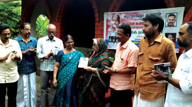 Writer Khadeeja Mumtaz hands over the first copy of Rafi Neelankavils Ummini Balya Mash to Jameela Akbar. (Photo:  DC)