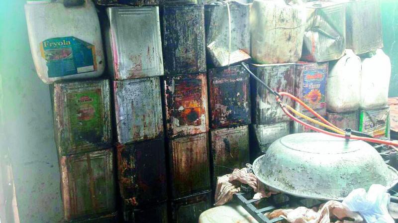 Oil tins stacked at an illegal oil producing unit, which was shut after GHMC raided it at Ramakrishnapuram.