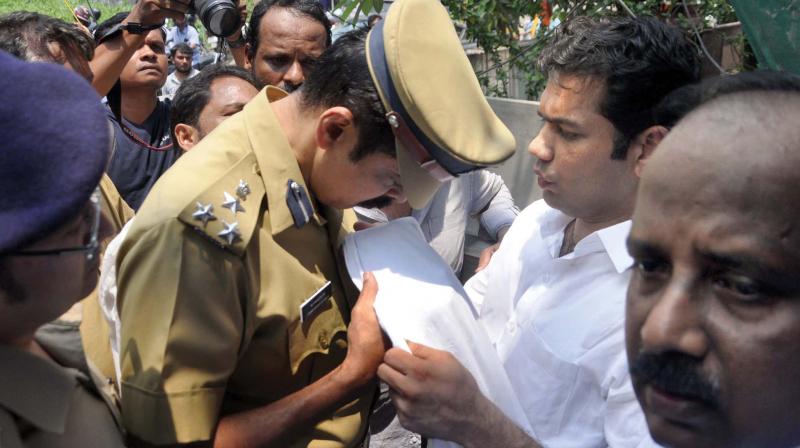 Kochi city police commissioner M.P. Dinesh examines the dhothi of MLA Hibi Eden after he alleged that Consumerfed staff sprinkled urine at people protesting against a retail liquor outlet of Consumerfed at Ponnurunni in Kochi on Thursday. (Photo:  SUNOJ NINAN MATHEW)