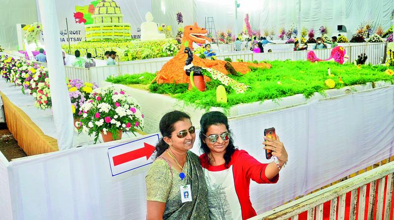 Women take a selfie at a flower show as part of Visakha Utsav at MGM Park in Visakhapatnam on Friday. (Photo: DC)