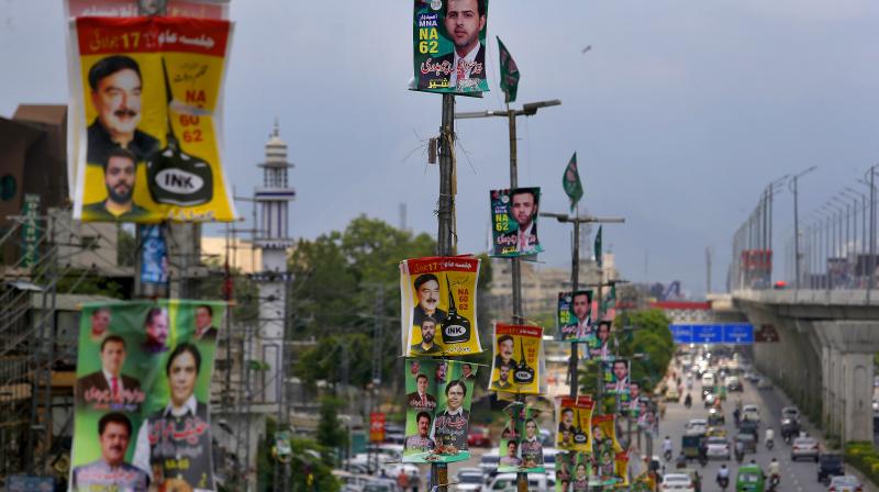 Banners of election candidates from political parties are displayed on poles on a highway in Rawalpindi, Pakistan, Tuesday. (Photo: AP)