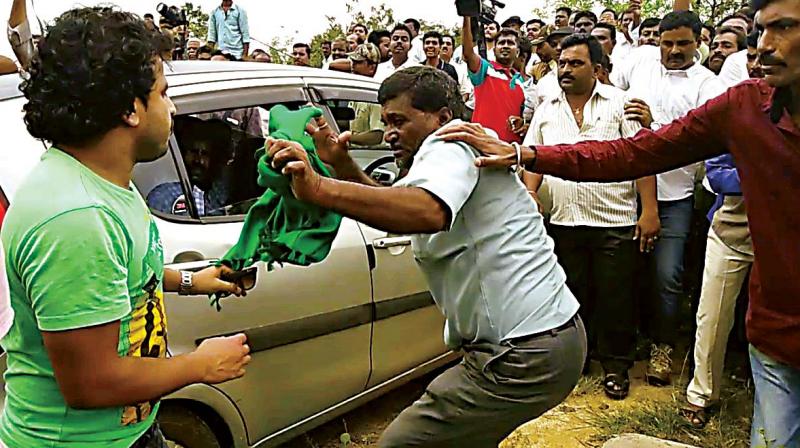 Farmers leader Kumar takes evasive action after he was attacked by JD (S) workers in Hassan on Saturday 	(Photo: DC)