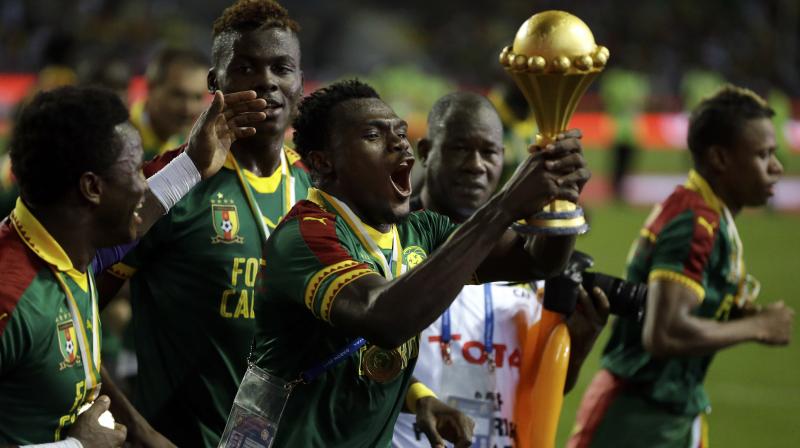Cameroon players celebrate with the trophy after the match. (Photo: AP)
