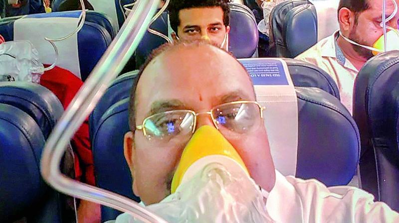 Passengers on board the Mumbai-Jaipur Jet Airways flight wear oxygen masks during an emergency after cabin pressure drop, in Mumbai, Thursday.	(Photo: PTI)