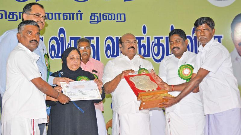 Fisheries minister D. Jayakumar gives a cash award to Dr Nilofer Kafeel, minister for labour and rural development. Minister P.Benjamin also present on the occasion organized by the labour department.(Photo: DC)