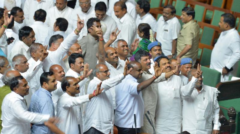 Members of the ruling party in the Karnataka Legislative Assembly show the victory sign after succesfully winning the trust vote session for the newly-sworn in chief minister of the JD(S)-Congress coalition government in the Karnataka Assembly at the Vidhana Soudha in Bengaluru on May 25.  (Photo:AFP)