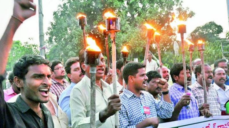 CPM activists hold a torchlight rally demanding Special Category Status for AP at the GVMC Gandhi Statue in Visakhapatnam on Wednesday. (Photo: DC)