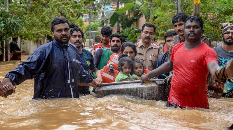 Rescuers evacuate people from a flood-hit locality, in Thiruvananthapuram on Wednesday. (Photo: PTI)