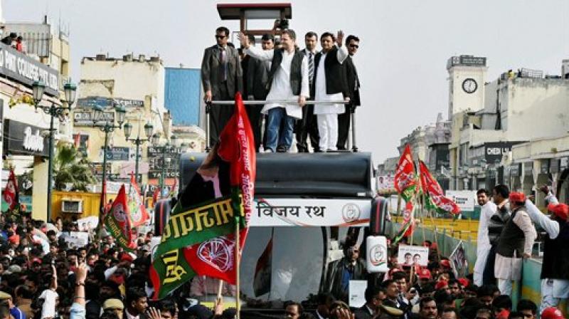 Uttar Pradesh Chief Minister and newly appointed party president Akhilesh Yadav with Congress Vice President Rahul Gandhi in a road show in Lucknow on Sunday. (Photo: PTI)