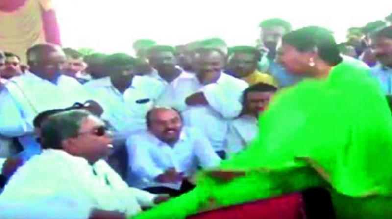Former Karnataka CM Siddaramaiah snatches a microphone from a woman dislodging her dupatta at an event in Varuna in Mysuru on Monday. Following this the National Commission for Women wrote to the state police to probe his behaviour.