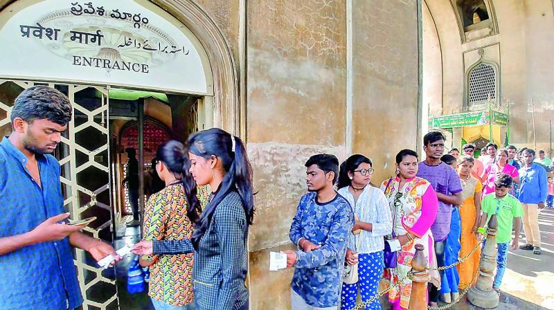 Tourists pay cash to buy tickets to enter the Charminar.     (Photo: DC)