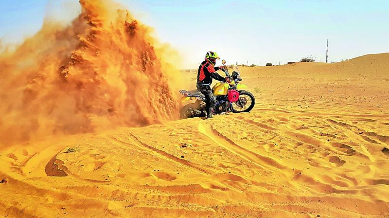 Pruthu doing a bike stunt on the sand dunes
