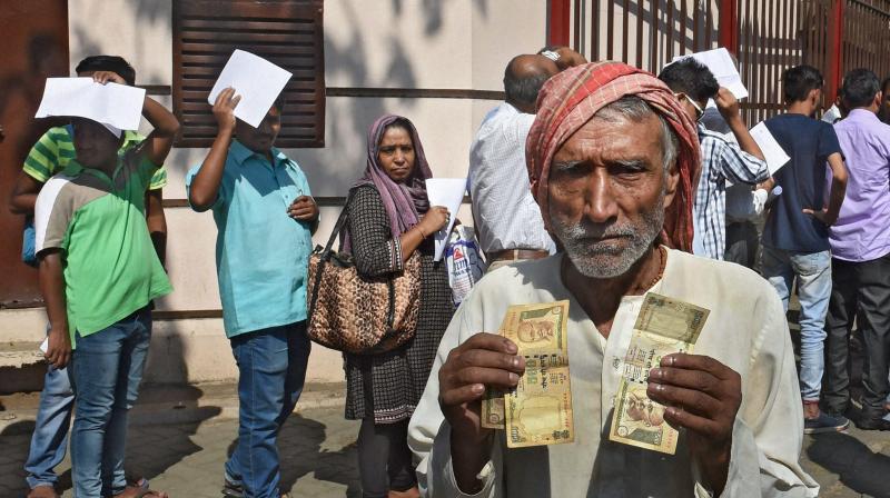 An elderly person showing old Rs 500 notes as people wait outside the Reserve Bank of India for exchange theom with new notes in Mumbai. (Photo: PTI)