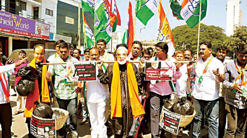 Congress leaders and workers protest against demonetisation at Anand Rao Circle in Bengaluru on Friday.