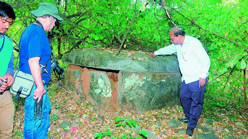 Archaeologists examine a dolmen at Dameravai in Tadwai mandal of Jaishankar Bhupalapally district.