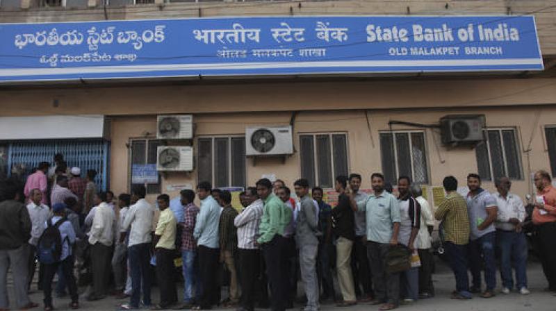 People stand in queue outside a bank before it opens to deposit and exchange rupees 500 and 1000 in Hyderabad. (Photo: AP)
