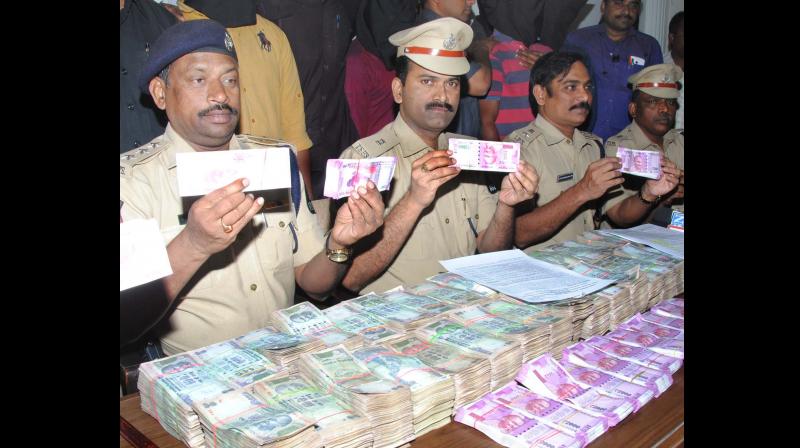 Police with the seized currency notes