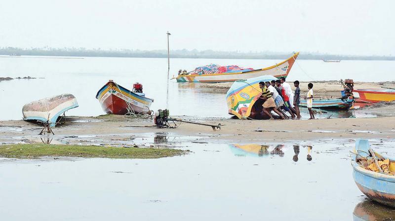 Fishermen attempt to retrieve their boats, which had overturned due to the impact of cyclone Vardah, to safer grounds on Tuesday (Photo: N. Sampath)