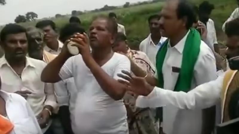 The farmer pretends to consume pesticide in front of the camera. (Photo: YouTube screenshot)