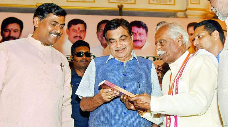 BJP MP Bandaru Dattatreya presents a copy of the Hindi version of Bhagavad Gita to Union minister Nitin Gadkari at a function held in Secunderabad on Tuesday.