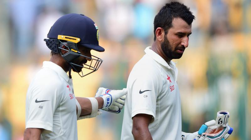 Indias Cheteshwar Pujara and Ajinkya return to pavilion after the end of third days play of the second test match against Australia at Chinnaswamy stadium in Bengaluru on Monday. (Photo: AP)