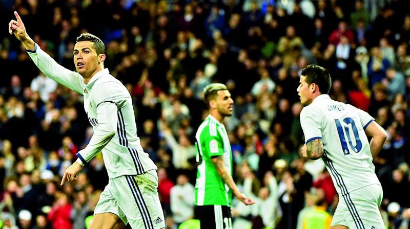 Real Madrids Portuguese forward Cristiano Ronaldo (left) celebrates a goal as teammate and Colombian midfielder James Rodriguez (right) joins in during their Spanish league match against Real Betis at the Santiago Bernabeu stadium in Madrid on Sunday. (Photo: AFP)