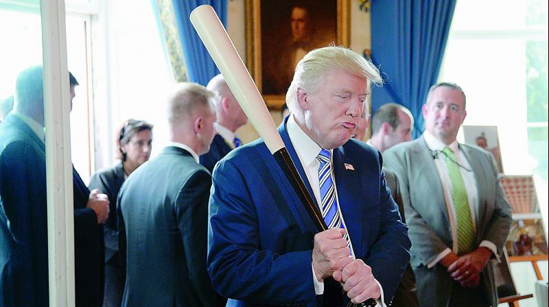 US President Donald Trump examines US-made products from all 50 states including a Marucci baseball bat during a  Made in America  product showcase event in Washington, DC, on Tuesday. 	 AFP