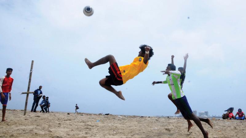 Young guys play football on the beach. (Photo: DC)