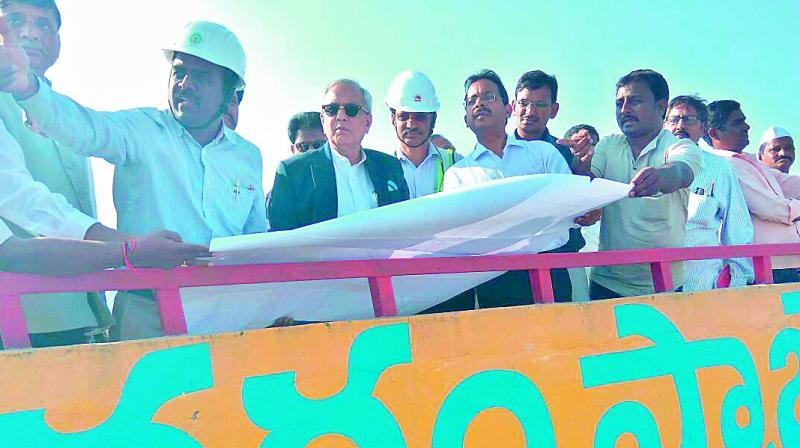 Niti Aayog vice chairman Dr Rajiv Kumar takes a look at the ongoing works of Polavaram project as the water resources officials explain on map at Hill View at the project site at Polavaram in West Godavari on Thursday. AP Planning Commission deputy chairman Kutumba Rao and officials are seen.