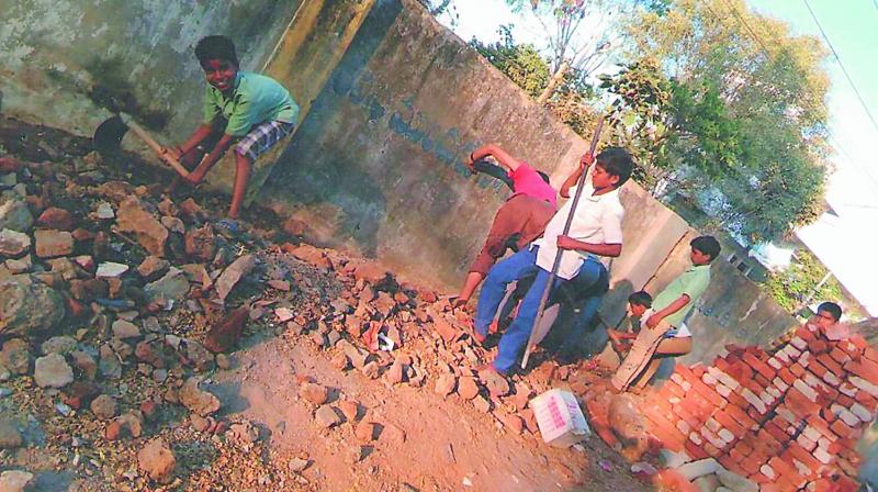 A photograph shows the students working near the compound of the Zilla Parishad High School at Shivrampally in Ranga Reddy district