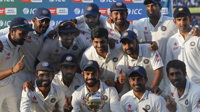 The Indian cricket team poses for photographs with the ICC Test Championship mace at the end of their third test cricket match against New Zealand in Indore. (Photo: AP)