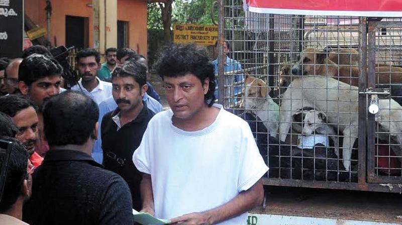 Boby Chemmanur with the caged stray dogs in front of district Collectorate  in Kozhikode on Saturday. (Photo: DC)