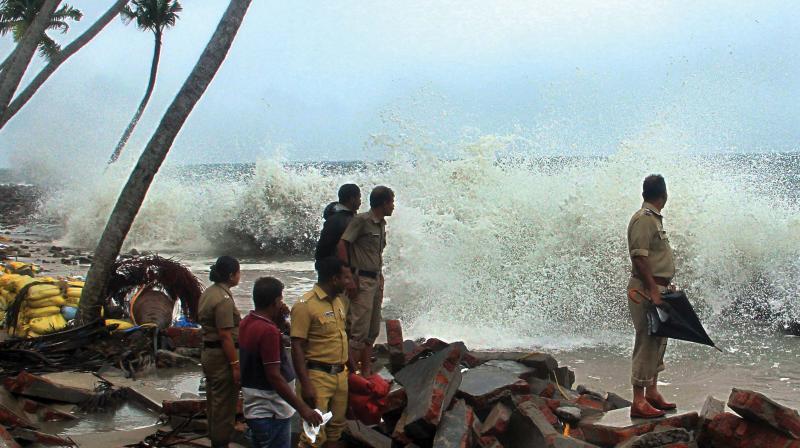 As pre-monsoon rains intensified, sea turned rough in many coastal areas. Residents and police officials of Chellanam watch the rough sea. (Photo: Arunchandra Bose)