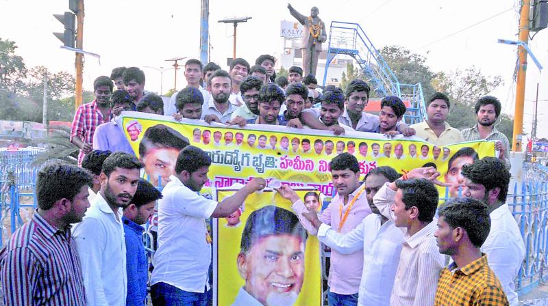 TNSF activists perform palabhishekam to AP Chief Minister N. Chandra Babu Naidus flexi hailing him for the sops announced for the unemployed youth in the Budget in Guntur on Wednesday. (Photo: DC)