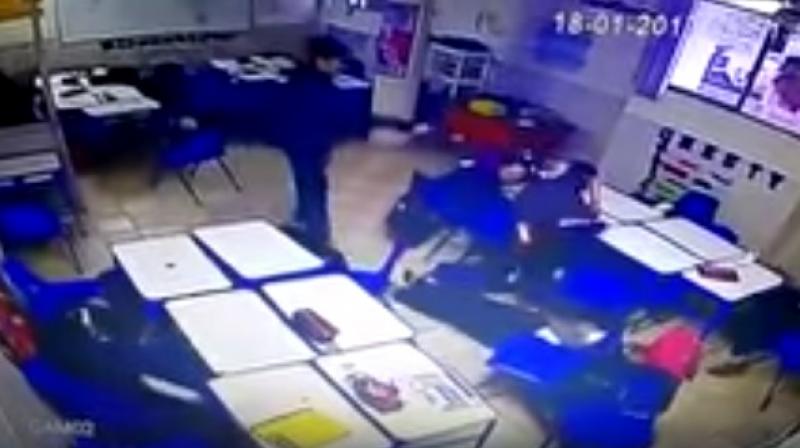 The video shows a female teacher handing out materials and students seated at their desks when a boy opens fire with a pistol from a sitting position. (Photo: Videograb)