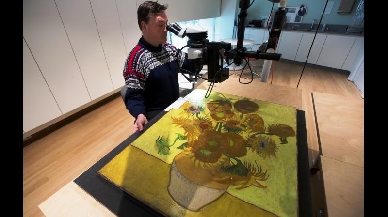 Senior paintings conservator Rene Boitelle works on restoring Vincent van Goghs world-famous \Sunflowers\ painting at the Van Gogh museum in Amsterdam, Netherlands. (Photo: AP)